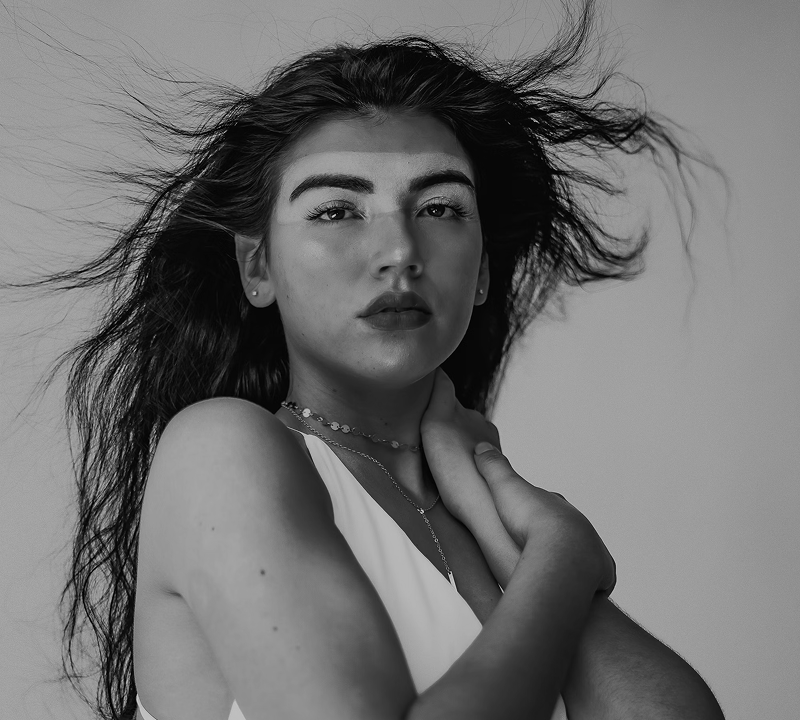 Black and white portrait of a dance instructor against a light background.