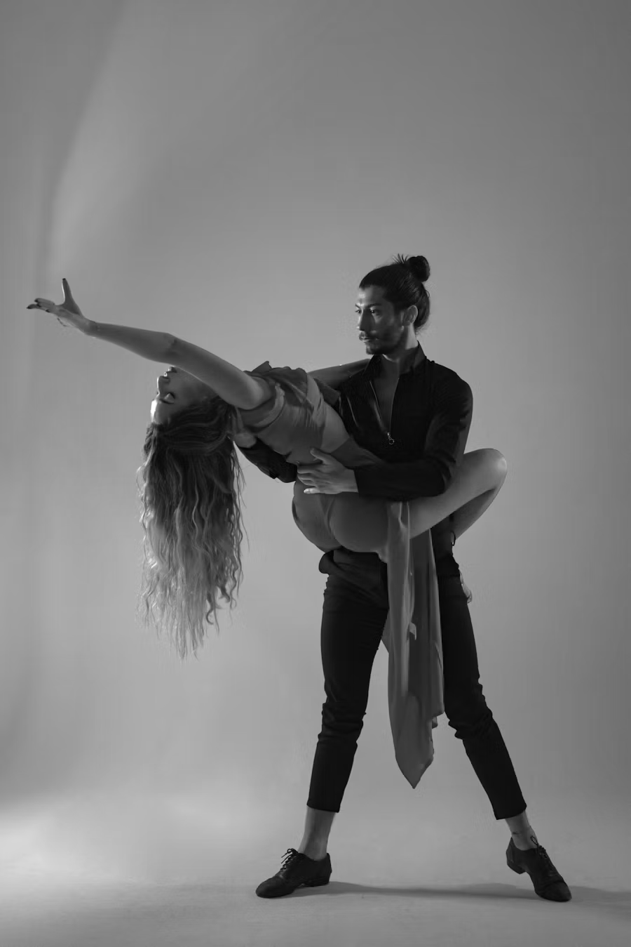 Black and white photo of a man and woman doing an intimate dance.