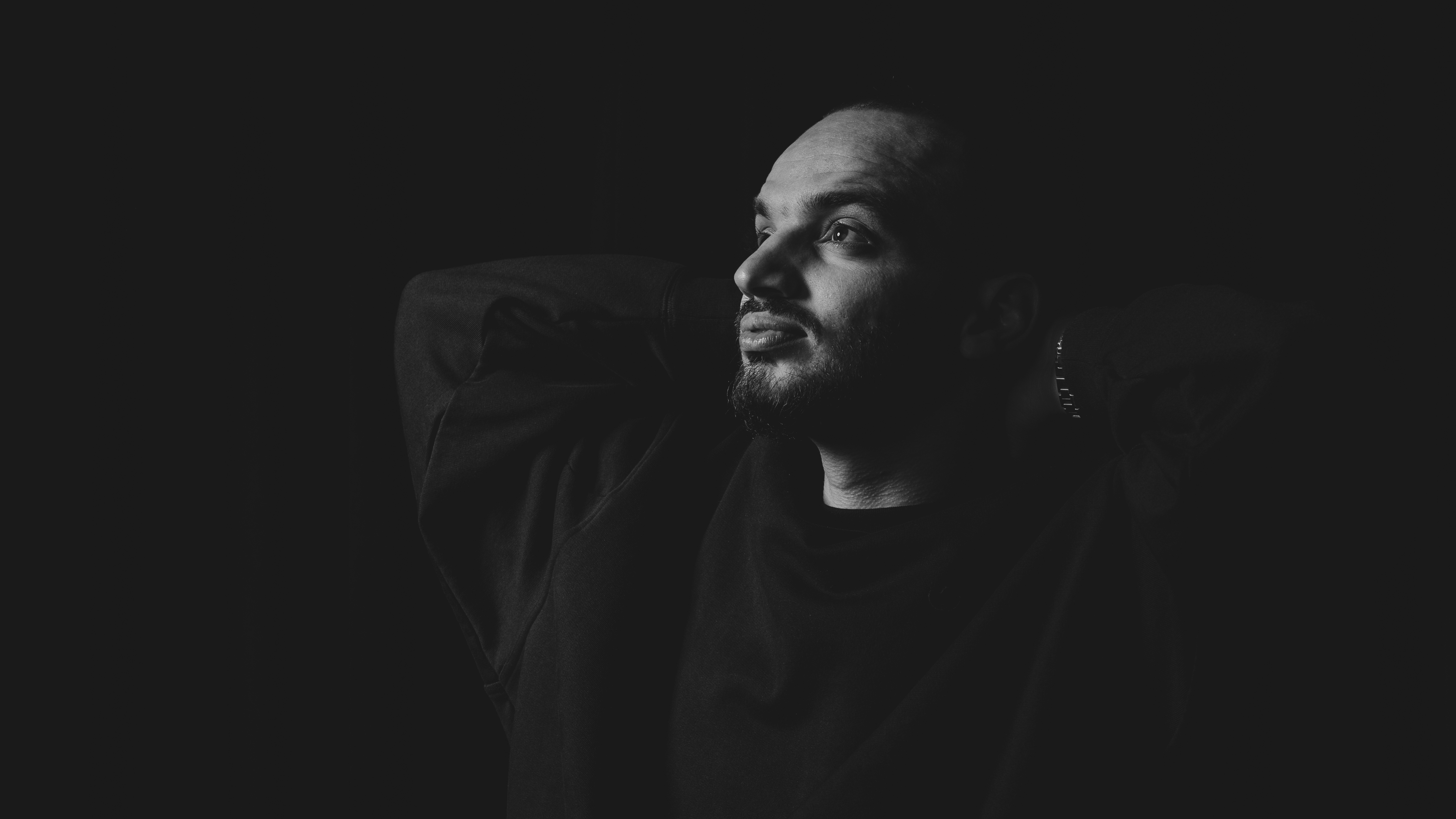 Black and white photo of a women performing modern dance on a dark background.